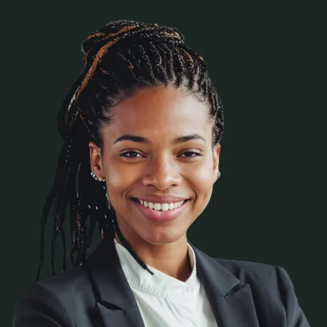 Smiling woman with braided hair wearing a black blazer and white blouse, against a dark background.